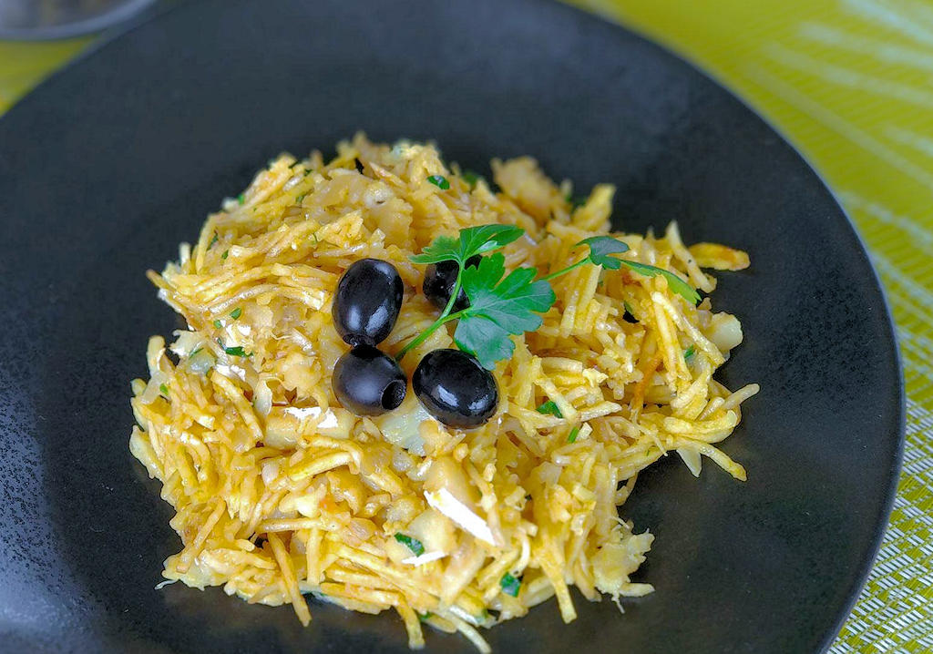 Indulge in the rich flavors and history of Bacalhau à Brás, a traditional Portuguese dish that combines salted codfish, potatoes, eggs, and more. Experience the essence of Portuguese culinary heritage.