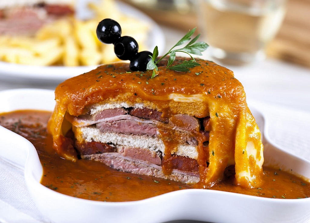 Embark on a culinary adventure in Porto as you savor the flavorsome layers of meat, melted cheese, and savory sauce that define the iconic Francesinha sandwich.